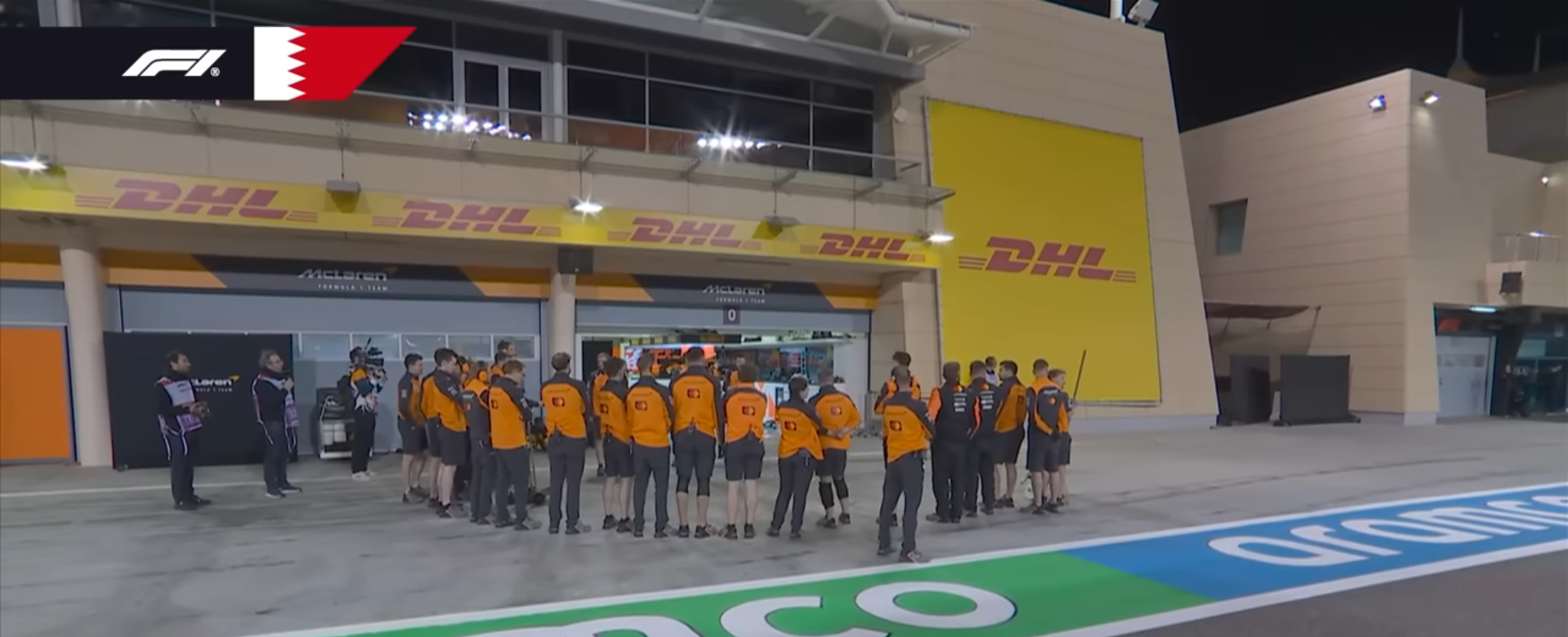 The McLaren team hides their car from the camera man's view.